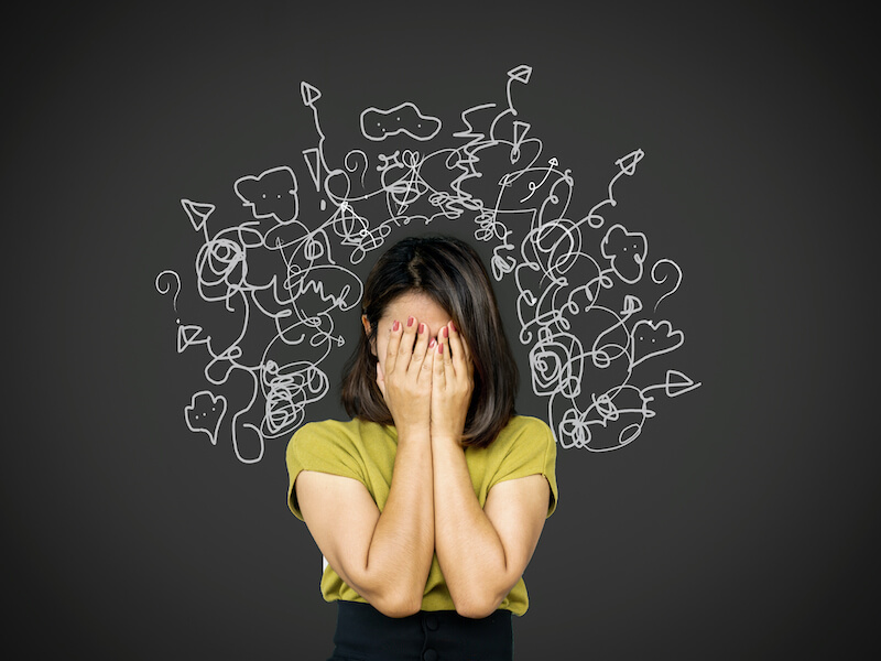 A black background with a woman who is hearing things in stereo and suffering from diplacusis.