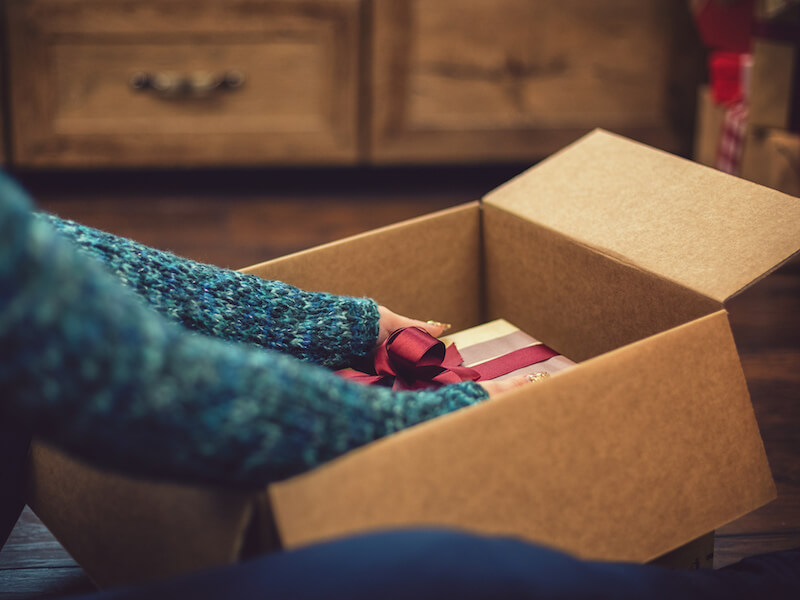Woman packing a holiday gift into a box now that she has hearing aids.