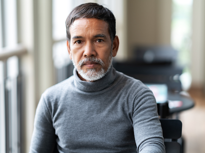 Man feeling anxious because he can’t hear the conversation.