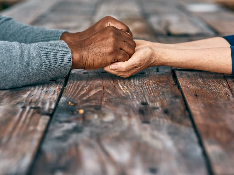 Cropped shot of two unrecognizable people holding hands discussing hearing loss with compassion.