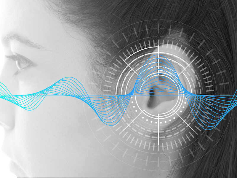 Hearing test showing ear of young woman with sound waves simulation technology - isolated on white banner - black and white.